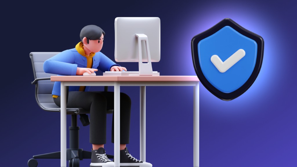 A person working at a computer beside a security shield